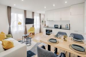圣加仑EH Apartments Jupiter的厨房以及带桌椅的起居室。