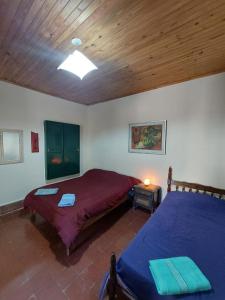 蒂尔卡拉Postales del Tiempo的一间卧室设有两张床和木制天花板