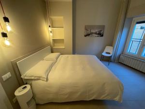 布雷西亚Ca'Sazen Bilo 20的卧室配有白色的床和窗户。