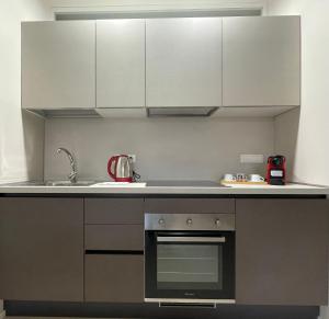 布雷西亚Ca'Sazen Bilo 20的厨房配有炉灶和白色橱柜。