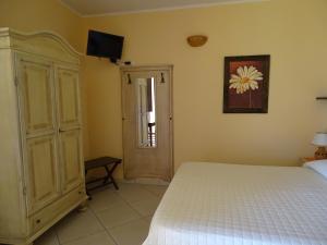 奥特朗托Sole del Mediterraneo的卧室配有一张床,墙上配有电视。