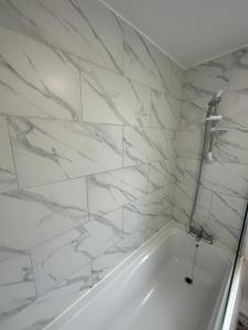 凯特林3 Bedroom House For Corporate Stays in Kettering的浴室设有白色浴缸,拥有大理石墙壁。
