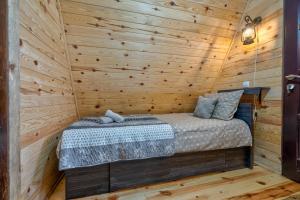 兹拉蒂博尔Vila Deniri的小木屋内的一张床位,设有木墙