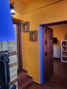 努瓦洛斯Casa Rural Reyes的一间设有蓝色和黄色墙壁和门的房间