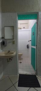 埃斯孔迪多港Chante的一间带水槽的浴室和通往卫生间的门