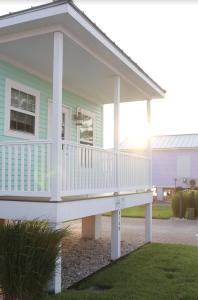 钦科蒂格Key West Cottages的一座带白色甲板的绿色小房子