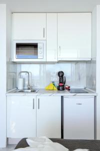 法纳贝海滩SEA LA VIE Ponderosa 617的白色的厨房配有水槽和微波炉