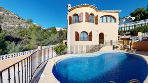 库姆布勒德尔索尔Villa Encinas的别墅前设有游泳池