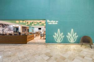 瓦哈卡市瓦哈卡嘉年华酒店的一间有蓝墙的餐厅,里面种有植物