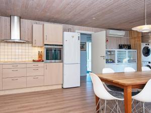 安斯艾厄Holiday home Ansager XXXIV的厨房配有木桌和白色冰箱。