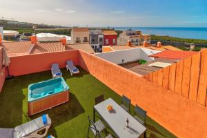 圣胡安海滩Bonita Casa Nina con Jacuzzi By Paramount Holidays的一座橙色的建筑,屋顶上设有游泳池