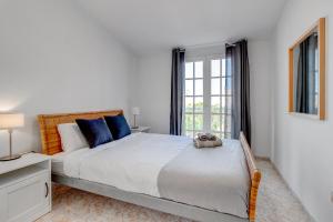 圣胡安海滩Bonita Casa Nina con Jacuzzi By Paramount Holidays的白色的卧室设有一张大床和一个窗户