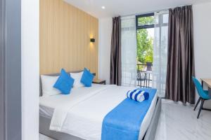 丹格迪Atoll Residence Dhangethi的一间卧室配有一张带蓝色枕头的大床