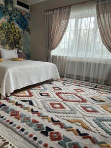 赫梅利尼茨基Tamerlan的卧室配有一张床,地板上铺有地毯