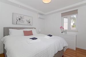 扎通Seaside Apartment M Zaton 5 - Sea View & Parking的白色卧室配有一张带白色床单的大床
