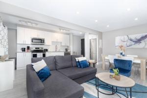 埃德蒙顿Modern & Stylish 1-Bedroom Unit的一间带灰色沙发的客厅和一间厨房