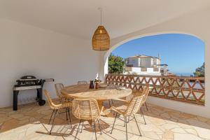 贝纳尔马德纳Luxury Villa Andalucia Seaview Private Pool close to Centre的一个带桌椅和烧烤架的庭院