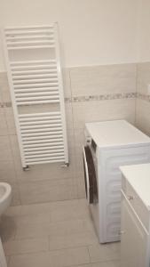 莱万托OASI FELICE的白色的浴室设有洗衣机和烘干机。