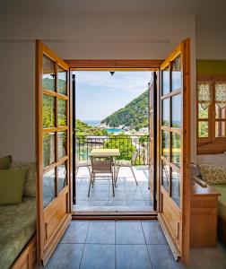 达默查理Olive House in Damouchari with a sea view - Delicious Houses的一间设有一扇门的客房,可通往带桌子的阳台