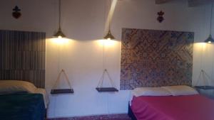 圣米格尔-德阿连德PATIO Alojamiento的卧室配有两张床,墙上有灯