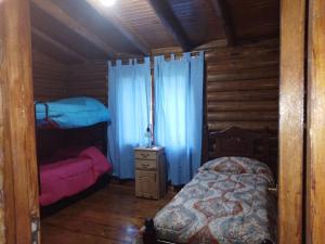 Colonia Las RosasCABAÑAS LAS ACACIAS的小木屋内一间卧室,配有一张床