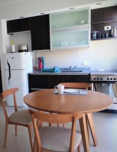布宜诺斯艾利斯Blue Bird Studio Baires的带木桌和椅子的厨房以及带白色冰箱的厨房。