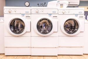 盐湖城Sonesta Simply Suites Salt Lake City Airport的洗衣房里堆放了三台洗衣机