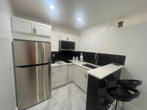 迈尔斯堡Villa San Carlos Park的厨房配有白色橱柜和不锈钢冰箱