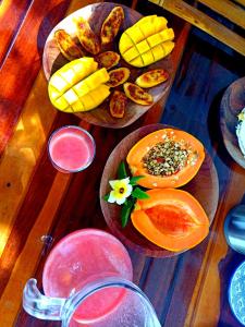 哥隆巴奥Odoyá Corumbau的一张木桌,上面放着两盘食物和水果