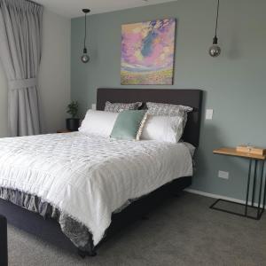 巴尔克拉萨Piwakawaka Suite的一间卧室配有带白色床单和枕头的床。