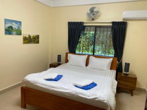 西哈努克Villa Blue Lagoon的一间卧室配有一张带蓝色拖鞋的床。
