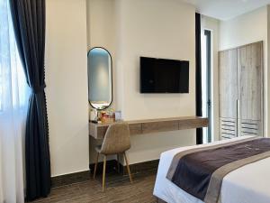 芹苴LION 5 HOTEL的一间卧室配有一张床、镜子和电视