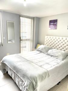 帕斯托Hermoso apartaestudio moderno valle de atriz norte的卧室内的一张大白色床,带有窗户