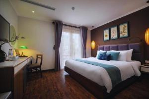 河内Hotel Emerald Waters Classy的酒店客房设有一张大床和一张书桌。