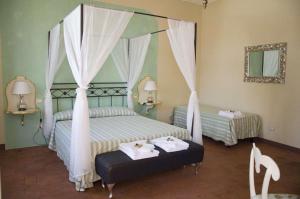 卢卡安菲堤亚特洛B&B酒店的一间卧室配有两张床和一张天蓬床。