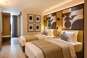 乌代浦Parallel Hotel Udaipur - A Stylish Urban Oasis的一间酒店客房,房间内设有两张床