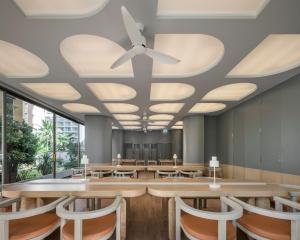 芭堤雅市中心Terra Nara的一间带桌椅和天花板的用餐室