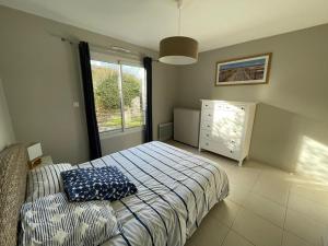 卡布勒通Appartement Capbreton, 2 pièces, 4 personnes - FR-1-413-133的一间卧室配有一张床、一个梳妆台和一扇窗户。