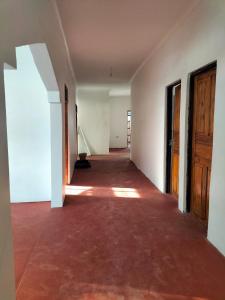 帕杰Mambo Leo Hostel的空屋空空的走廊,有地板和木门
