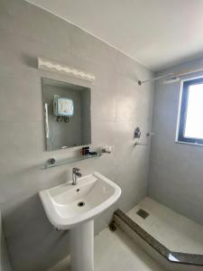 加德满都YULOKO GUEST HOUSE的白色的浴室设有水槽和镜子