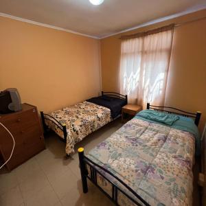 卡拉马HOSPEDAJE DA VINCI PARA TURISTAS y PERSONAL LABORAL的一间卧室配有两张床和电视。
