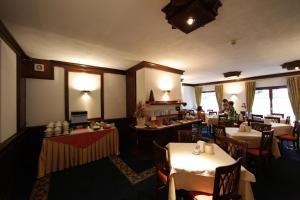安塔格诺德小王子酒店的一间设有桌椅的餐厅,以及一位背景人士