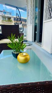 皮特尔角城Urban Zen Appart Spacieux studio atypique avec bain a remous proche de tout的坐在玻璃桌前的黄色花瓶