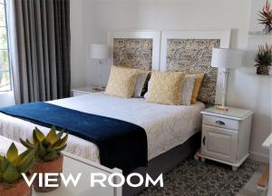 约翰内斯堡Hadeda Hall的一间卧室配有一张大床,提供蓝色毯子和枕头