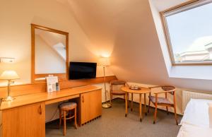 莫雄马扎尔古堡特玛尔水疗酒店的客房设有书桌、镜子和床。
