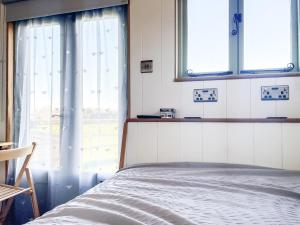 LangstoneThe Hut的一间卧室设有一张床和两个窗户。