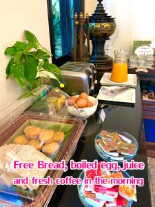 清迈乌莱萨拜迪住宿加早餐旅馆的早晨的桌子上放着面包和新鲜咖啡