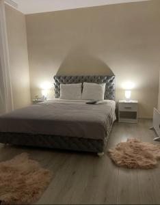 查查克Apartman Smile的一间卧室配有一张大床和两张地毯。