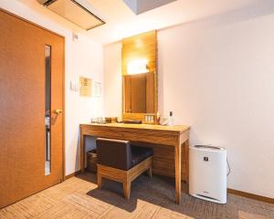 大阪难波大国町瑞利弗酒店的客房设有带椅子和镜子的书桌