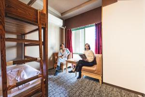 大阪难波大国町瑞利弗酒店的两位女士坐在带双层床的房间里桌子上